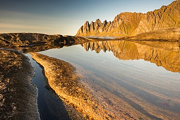 Reflection in rock pool of Devil's Teeth Mountains, from Tungenet, evening sunlight, Senja, Norway, Scandinavia, Europe