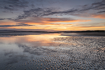 Sunset reflections on sandy beach at sunset, Camber Sands, East Sussex, England, United Kingdom, Europe