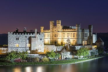 Leeds Castle and moat at night with decorated Christmas tree, near Maidstone, Kent, England, United Kingdom, Europe