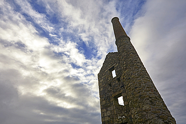 The ruined engine house of Carn Galver tin mine against the afternoon light, near Pendeen, Cornwall, Great Britain.