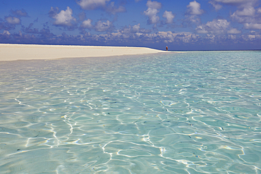Pristine shallow waters lap against the white coral sand of a tropical beach; Havodda Island, in the far south of the Maldives, Gaafu Dhaalu atoll, Indian Ocean.