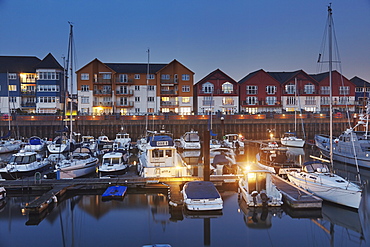 A dusk view of modern harbourside housing, beside the estuary of the River Exe, at Exmouth, Devon, England, United Kingdom, Europe