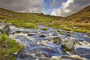 A moorland river rushes downill through a valley, en route from the moors to the sea, the River Tavy, in Dartmoor National Park, Devon, England, United Kingdom, Europe