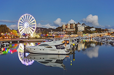 An atmospheric dusk view across Torquay Marina to the town of Torquay, on the south coast of Devon, England, United Kingdom, Europe