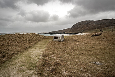 Abandoned caravan at Cleit Beach in rain and stormy weather, Barra, Outer Hebrides, Scotland, United Kingdom, Europe