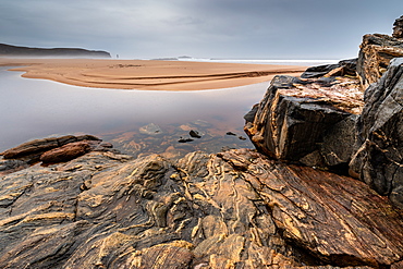 Rock formations at Sandwood Bay, with Am Buachaille sea stack in far distance, Sutherland, Scotland, United Kingdom, Europe