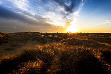 Sunset over the dunes and the Parish Church of the Holy Trinity and All Saints at Winterton on Sea, Norfolk, England, United Kingdom, Europe