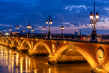 Historic bridge, Pont de Pierre over the Garonne River at blue hour (dusk), Bordeaux, Gironde, Nouvelle-Aquitaine, France, Europe