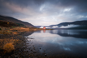 Abandoned pink house on Loch Glass, Highlands, Scotland, United Kingdom