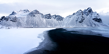 View of the mountains of Vestrahorn from black volcanic sand beach after snowfall, Stokksnes, South Iceland, Iceland, Polar Regions