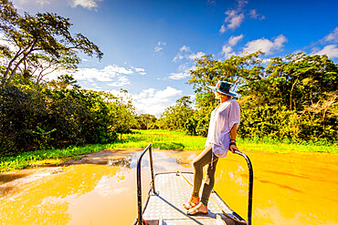 Woman searching for wildlife on a boat tour of the Amazon River, Peru, South America