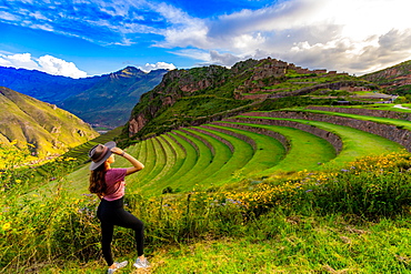 Girl gazing out at the mountain side Inca terraces at Pisac, Peru, South America