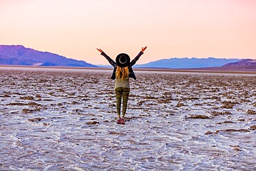 Model posing for the camera at sunset over the salt flats of the Mesquite Dunes, California, United States of America, North America