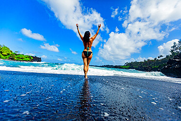 Woman enjoying the sun on one of Maui's black sand beaches, Hawaii, United States of America, North America