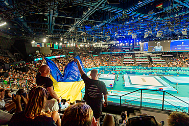 Patriotic Ukrainian men cheering on men's gymnastics at the Paris 2024 Olympics, Bercy Arena, Paris, France, Europe