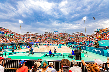 Jumping and cheering for Team USA and the Paris 2024 Olympics in Paris in front of the Eiffel Tower beach volleyball stadium, Paris, France, Europe