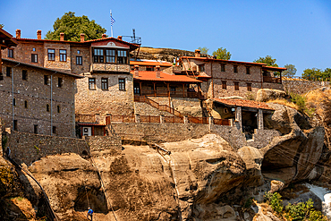 Holy Monastery of Varlaam built atop the rock formations of Meteora, with its stone structures and terraced balconies overlooking the valley.