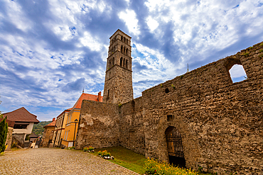 Ground-level view of the Romanesque bell tower of Saint Luke and the stone ruins of the Church of Saint Mary in Jajce, a significant medieval landmark in the historic town.