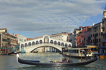 A gondola crossing the Grand Canal with a vaporetto and the Rialto Bridge beyond, Venice, UNESCO World Heritage Site, Veneto, Italy, Europe