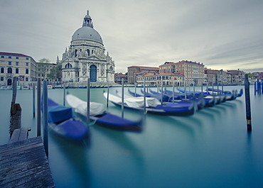 The 17th century church of Santa Maria della Salute across the Grand Canal with a row of gondolas slowly moving in the wind, Venice, UNESCO World Heritage Site, Veneto, Italy, Europe