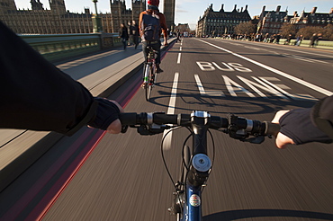 A cyclist crosses Westminster Bridge towards the Houses of Parliament, London, England, United Kingdom, Europe