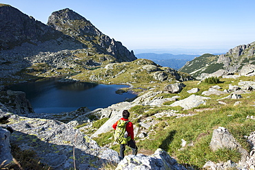 Hiking next to the clear water of Elenino Lake near Maliovitsa in the Rila Mountains, Bulgaria, Europe