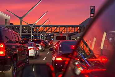 Traffic going into Los Angeles airport under a vibrant orange and pink sunset, California, United States of America, North America