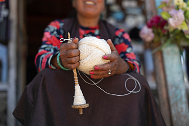 A Sherpa woman from Gosainkund spins baby Yak wool using the traditional method with a spindle, Langtang region, Nepal, Asia