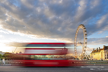 A red London bus goes past in a blur across Westminster Bridge with the London Eye and Southbank in distance, London, England, United Kingdom, Europe