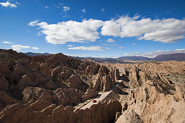 A car passes through the stunning rock formations of the Quebrada de las Flechas, Argentina, South America