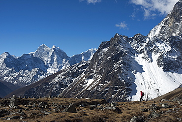 A trekker in the Everest region on the way up to Everest Base Camp seen here walking in front of Cholatse, Khumbu Region, Nepal, Himalayas, Asia