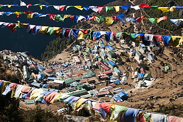 Buddhist prayer flags frame Namche Bazaar in the Khumbu Region, Nepal, Himalayas, Asia