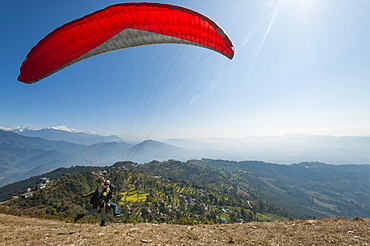 A tandem paraglider takes to the air from the top of Sarankot near Pokhara, Nepal, Himalayas, Asia