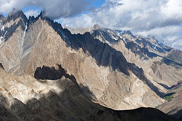 Light and shadow move across the jagged peaks of the Zanskar range seen from the top of the Dung Dung La in Ladakh, Himalayas, India, Asia