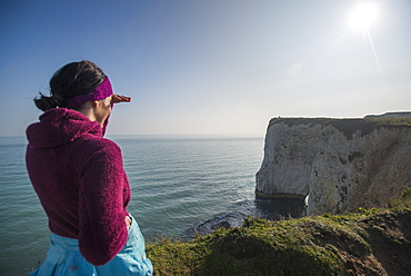 A woman looks out at Old Harry Rocks at Studland Bay, Jurassic Coast, UNESCO World Heritage Site, Dorset, England, United Kingdom, Europe