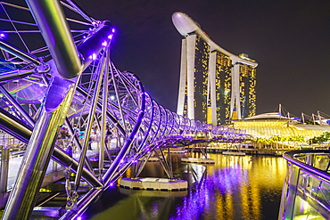 People strolling on the Helix Bridge towards the Marina Bay Sands and ArtScience Museum at night, Marina Bay, Singapore, Southeast Asia, Asia