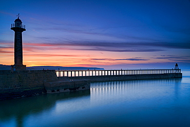 Sunset afterglow over Whitby West Pier and lighthouse, the North Yorkshire coast, Yorkshire, England, United Kingdom, Europe