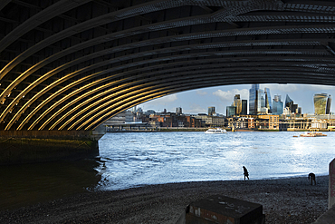 Beachcombers stroll beneath Blackfriars Bridge on the South Bank of the River Thames, London, England, United Kingdom, Europe