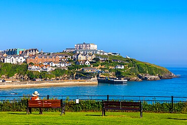 Visitor on bench admiring coastal view, Newquay, Cornwall, England, United Kingdom, Europe