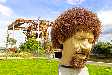 Statue of Luke Kelly, Sheriff Street Lifting Bridge in background, Linear Park, Dublin, Republic of Ireland, Europe