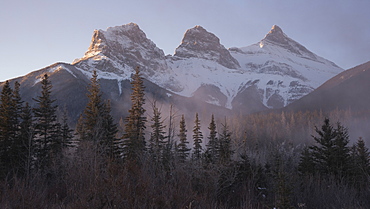 The Peaks of Three Sisters at sunrise in winter with mountain mist, Canmore, Alberta, Canadian Rockies, Canada, North America