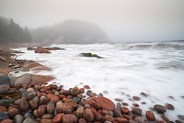 Long exposure of waves crashing on colourful pink rocks, Black Brook Cove Beach, Cape Breton, Nova Scotia, Canada, North America