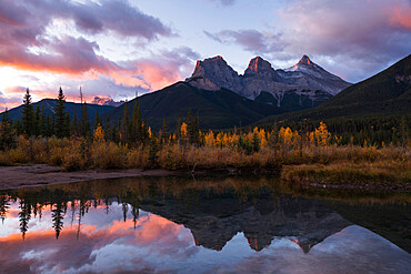 Colourful sunrise over Three Sisters at Policeman Creek in autumn, Canmore, Banff, Alberta, Canadian Rockies, Canada, North America