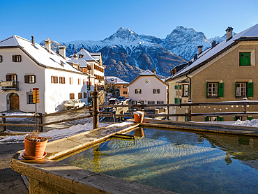 A plaza and fountain in the Alpine village of Sent in winter, Sent, Switzerland, Europe