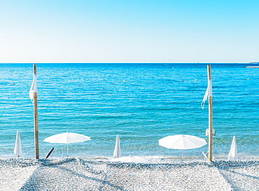 Giant white beach umbrella next to the ocean against a blue sky in Juan les Pins, Cote d'Azur, Provence, France, Mediterranean, Europe