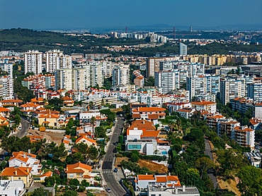 Aerial drone view of outskirts of Lisbon, Portugal facing towards the iconic 25 April Bridge, Portugal
