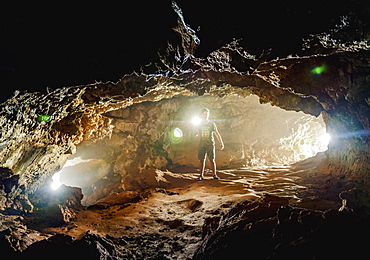 Tourist exploring the Ana Kakenga Cave, Rapa Nui National Park, UNESCO World Heritage Site, Easter Island, Chile, South America