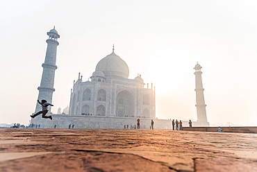 A man jumps as the sun rises behind the Taj Mahal, UNESCO World Heritage Site, Agra, Uttar Pradesh, India, Asia