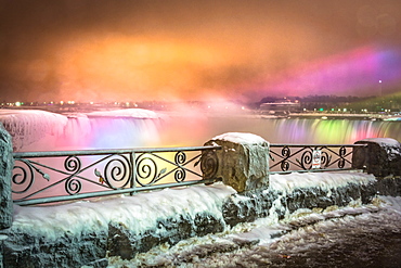 Frozen Niagara Falls in March illuminated at night, Niagara, Ontario, Canada, North America