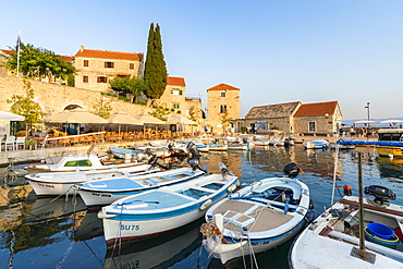 Boats at the pier of the town at sunset, Bol, Brac island, Split-Dalmatia county, Croatia, Europe